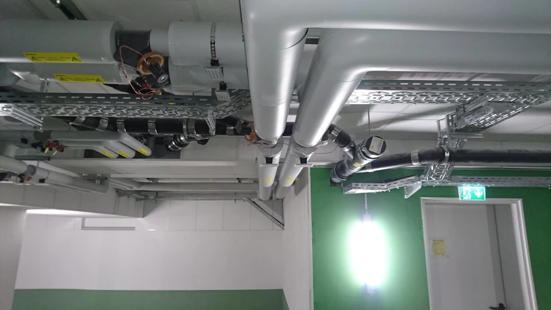 Instalacja grzewcza — szeroki widok tras rur i mocowań w strefie technicznej